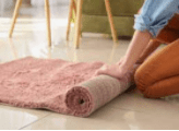 a person rolling up a rug
