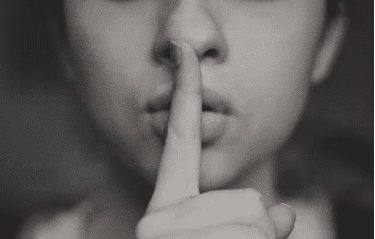 finger in front of mouth shh