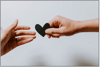 hands holding cut out heart shape