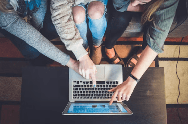 people pointing at a lap top