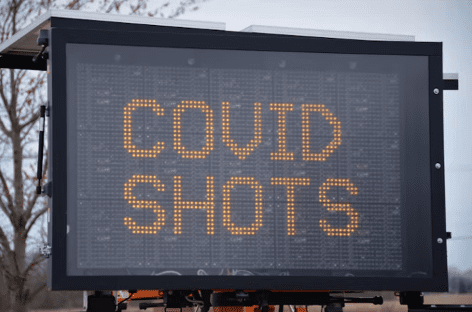 covid shots road sign