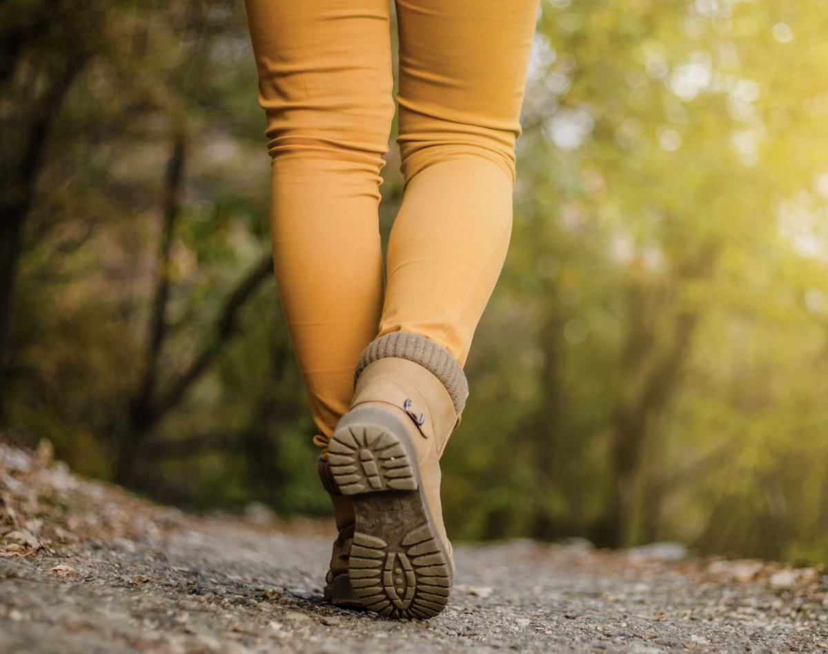 Close up of a woman's legs as she walks down a trail in a wooded area