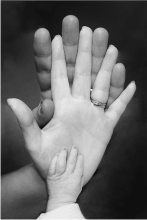black and white photo of different size hands together