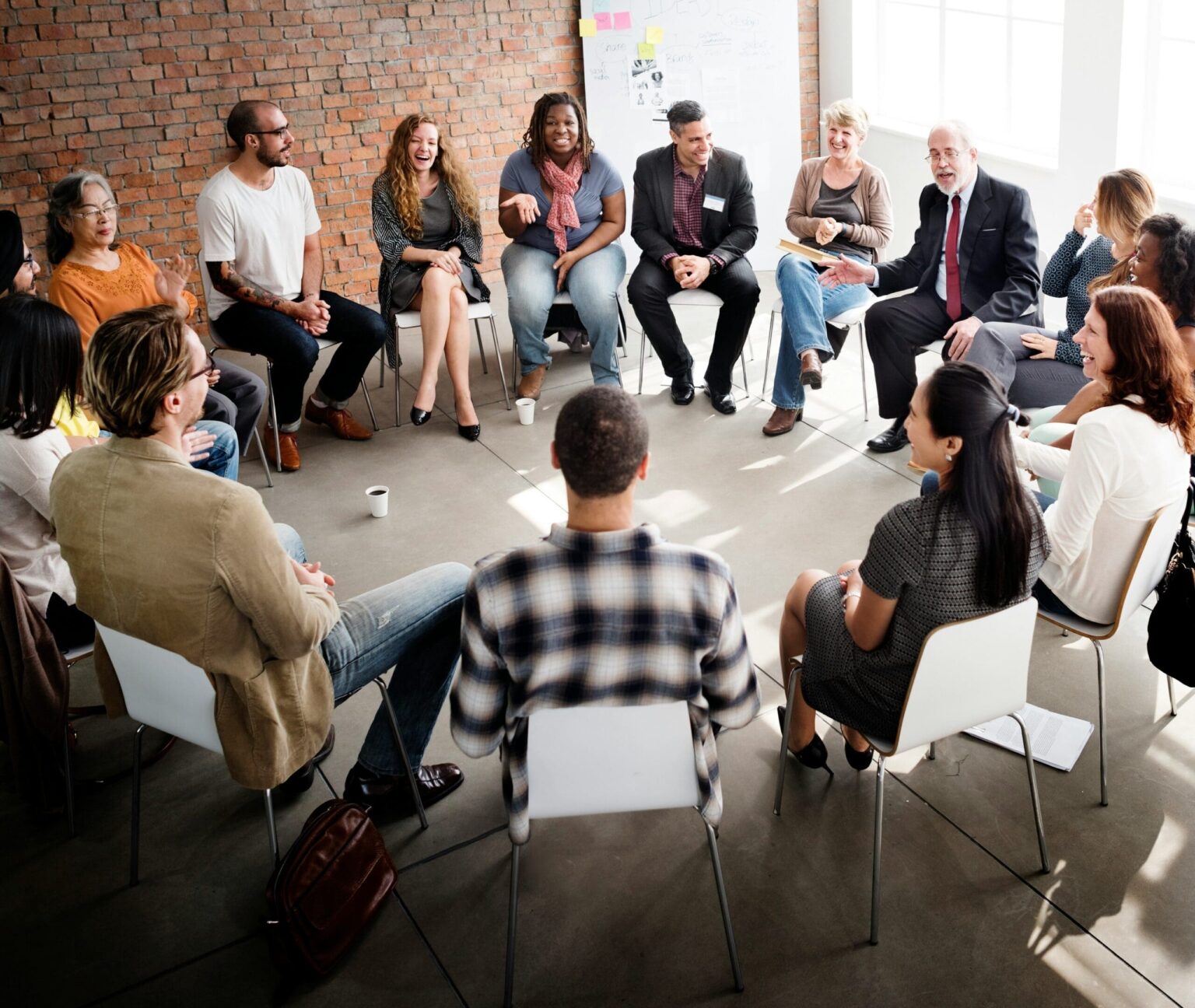A group of diverse men and women sitting in. a circle having a conversation