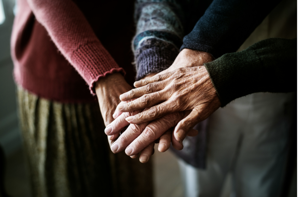 Close up of seniors with their hands on top of each other.