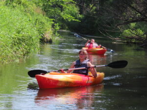 Campers kayaking in bright orange kayaks